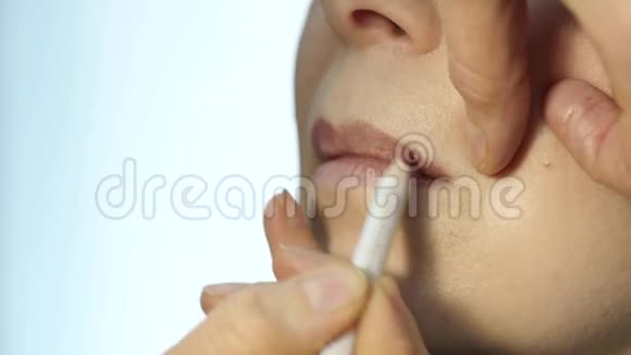 专业化妆师在模特嘴唇上应用轮廓时尚界化妆品视频的预览图