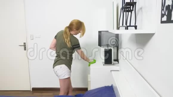 年轻女性用清洁产品和设备清洁卧室家庭工作概念视频的预览图