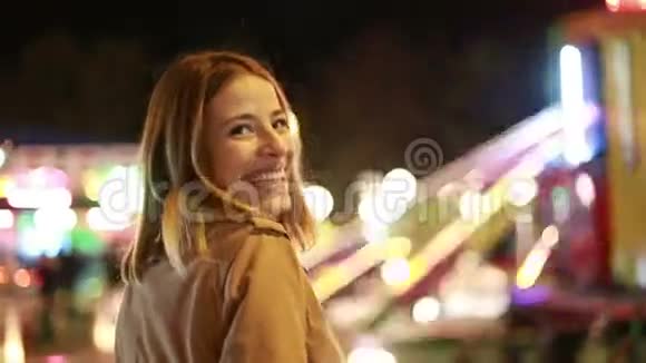在游乐园里一个年轻的女人笑着对着镜头挥手视频的预览图