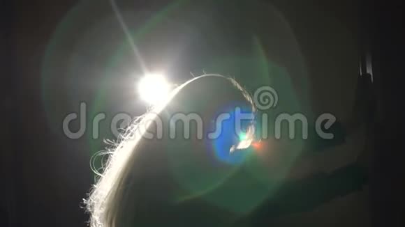 一个头发在黑暗中飘动的女孩的剪影视频的预览图