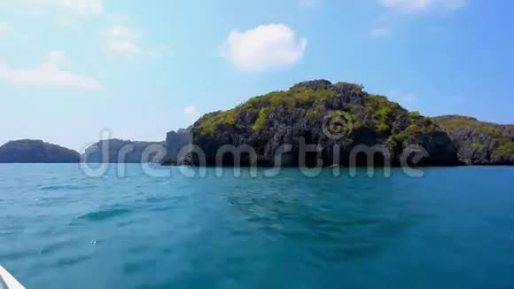 在一个岩石岛旁边航行快艇视频的预览图