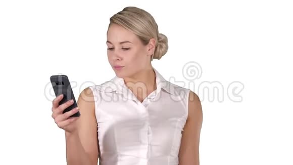 年轻女孩在白色背景下从手机屏幕上阅读视频的预览图