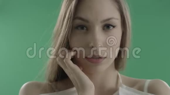 绿色背景下迷人的年轻女子视频的预览图