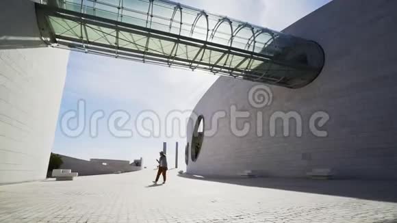 女人在现代建筑之间行走视频的预览图