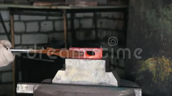 铁匠在工作时用电锤在铁砧上红热钢工艺视频的预览图