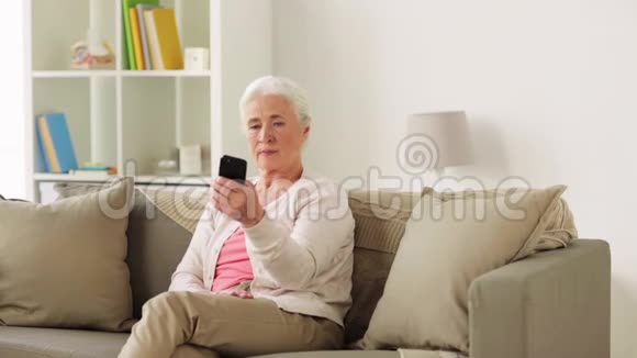 有智能手机的高级女性在家自拍视频的预览图