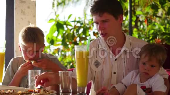 一家人在海滩上的餐馆吃饭视频的预览图