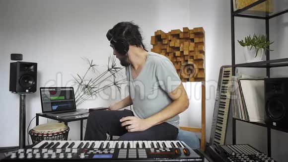 音乐家在家庭音乐工作室演奏MIDI键盘视频的预览图