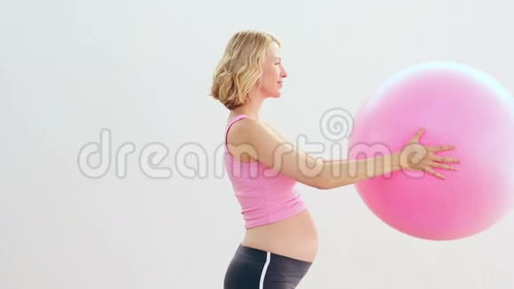 怀孕的金发女郎拿着运动球视频的预览图