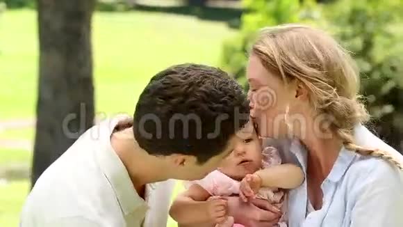 快乐的父母和他们的宝贝女儿在公园视频的预览图