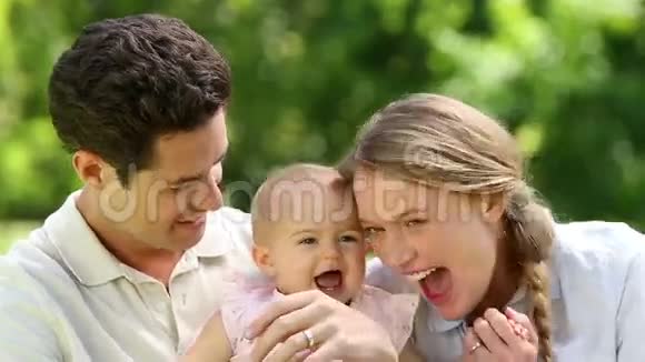 快乐的父母和他们的宝贝女儿在公园视频的预览图
