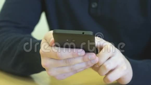 坐在书桌前的学生拿着智能手机视频的预览图