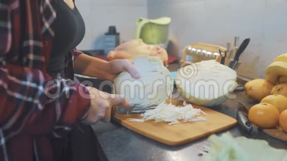 厨房里的女人准备一顿饭的概念厨房里的女孩用刀子切割卷心菜的生活方式做素食者视频的预览图