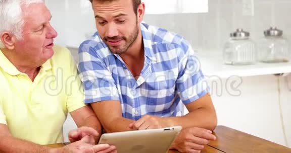 成熟的男人和男人在平板电脑前笑视频的预览图