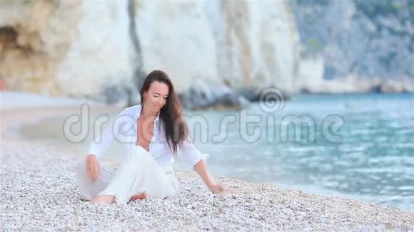 躺在海滩上享受暑假的女人望着大海视频的预览图