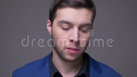 年轻英俊的白种人男性面部特写镜头镜头背景与灰色隔离视频的预览图