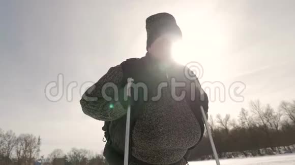 一位老年妇女在冬季森林里用木棍做北欧人的散步健康的生活方式观念成熟成熟视频的预览图