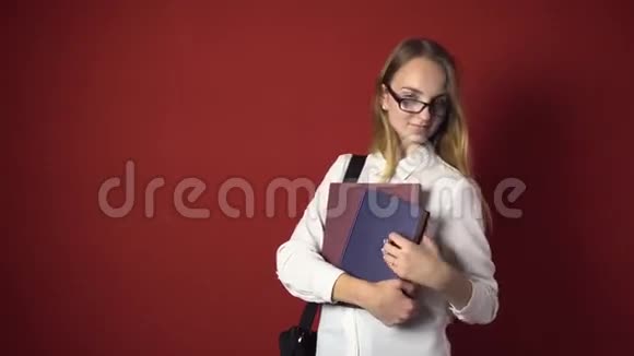 有魅力的学生金发女孩在红色面前微笑视频的预览图