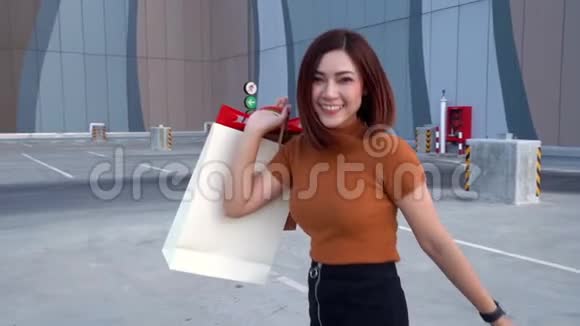 快乐的女人带着购物袋走路视频的预览图