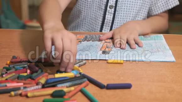 男孩用彩色粉笔和铅笔画画视频的预览图