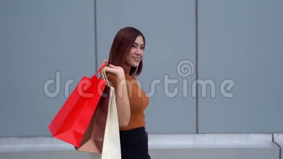 快乐的女人带着购物袋走路视频的预览图