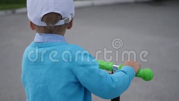 一个快乐的孩子在公园里骑着他的滑板车户外乐趣视频的预览图