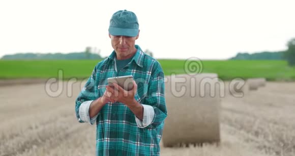 农民在检查农场时使用数字平板电脑视频的预览图