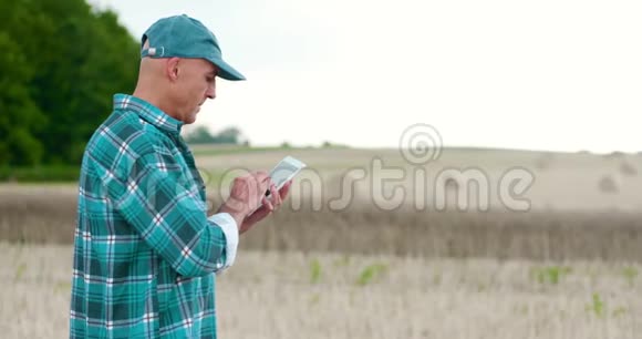 农民在检查农场时使用数字平板电脑视频的预览图