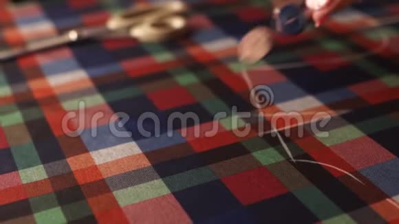衣服五颜六色的纽扣缓慢地落在格子织物上裁缝铺里布上的裁缝钮扣视频的预览图