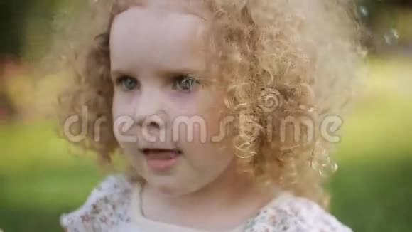 小女孩在夏天公园吹肥皂泡视频的预览图