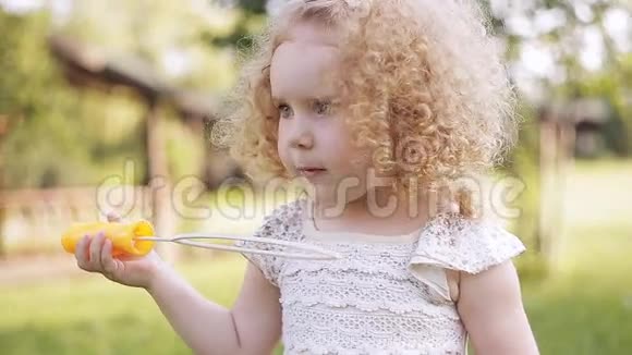 小女孩在夏天公园吹肥皂泡视频的预览图