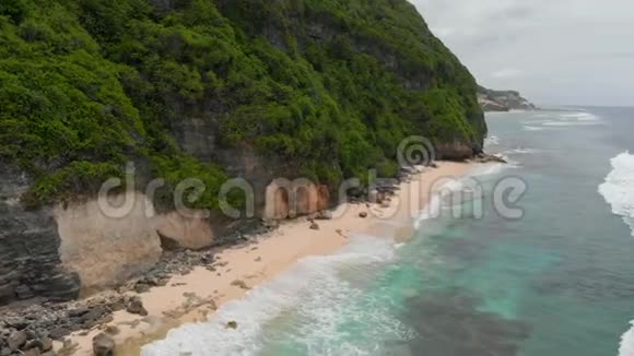 巴厘岛带悬崖和海洋的热带海滩鸟瞰图视频的预览图