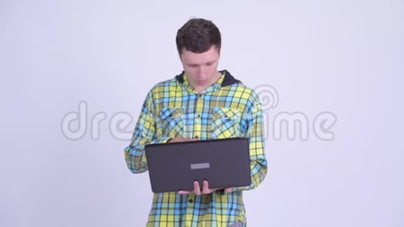 快乐的年轻帅哥在用笔记本电脑思考视频的预览图