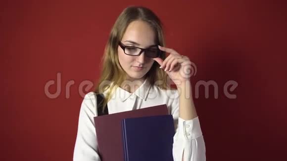 漂亮的学生金发女孩戴着红色眼镜视频的预览图