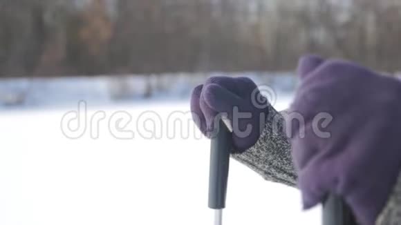 一位老年妇女在冬季森林里用木棍做北欧人的散步健康的生活方式观念成熟成熟视频的预览图