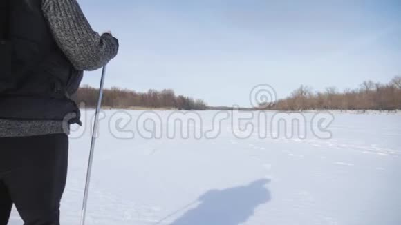 一位老年妇女在冬季森林里用木棍做北欧人的散步健康的生活方式观念成熟成熟视频的预览图