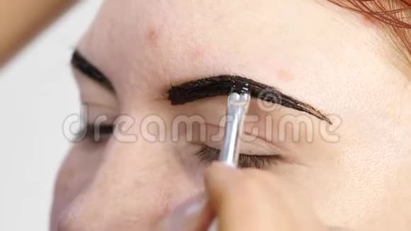 专业化妆师绘制美丽客户的眉毛美容和时尚概念视频的预览图