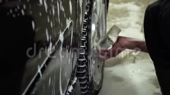 洗车一个洗车工洗车一个男人用泡沫海绵洗汽车特写镜头视频的预览图