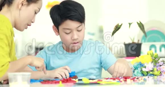 快乐的亚洲家庭母子一起玩塑料块视频的预览图
