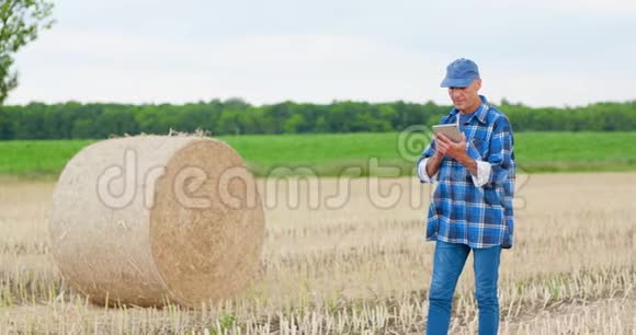 农民在检查农场时使用数字平板电脑视频的预览图