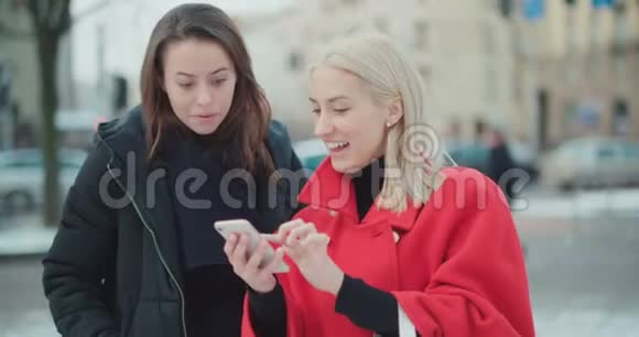 两个年轻女孩在一个城市使用手机视频的预览图
