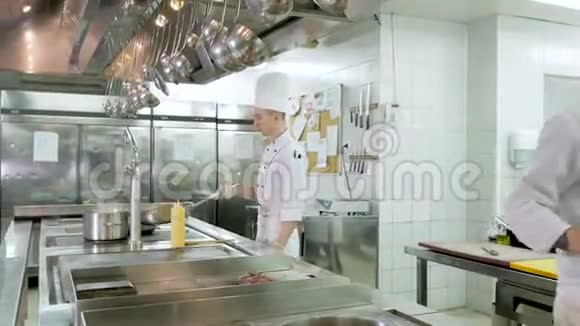 厨师在餐厅或酒店的厨房用平底锅煮蔬菜视频的预览图
