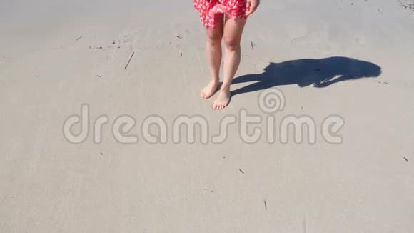 年轻的女人穿着红色的裙子在沙滩上画着一颗心海滩图纸的心脏慢动作视频的预览图