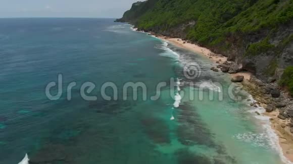 巴厘岛带悬崖和海洋的热带海滩鸟瞰图视频的预览图