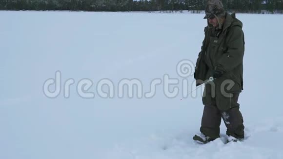 在冰冻的湖面上钓鱼的渔夫视频的预览图