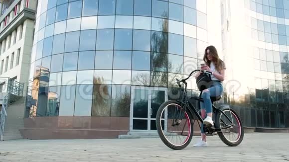 一个漂亮的女人骑着自行车在一栋4k的高楼旁视频的预览图