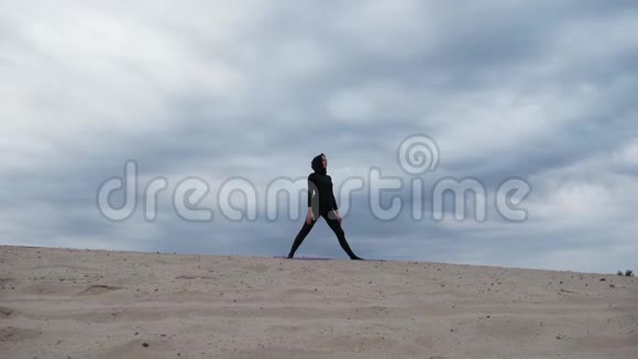 日落时分在沙漠中锻炼健康生活方式的穆斯林妇女视频的预览图