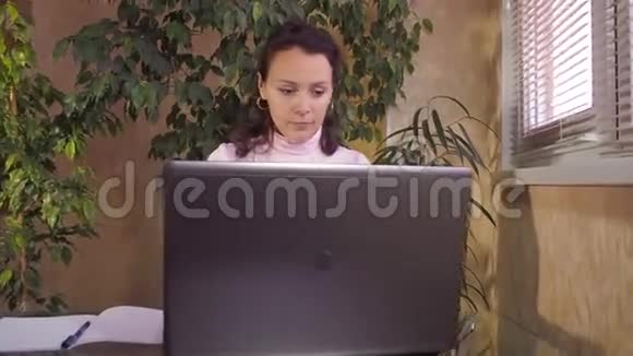 在家里用笔记本电脑工作的女孩视频的预览图