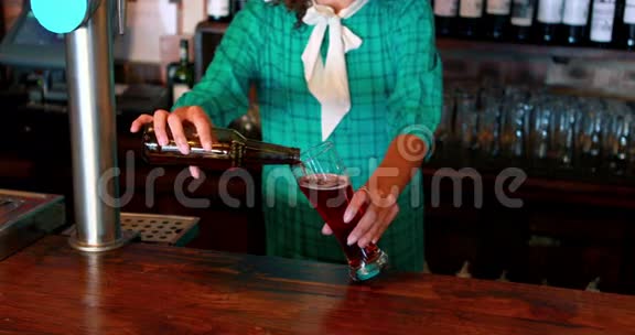 酒吧柜台的酒吧服务员往杯子里倒啤酒视频的预览图