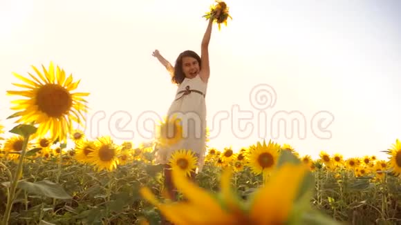 可爱的女孩在黄色的花园向日葵阳光在夏天的生活方式美丽的日落小女孩向日葵视频的预览图